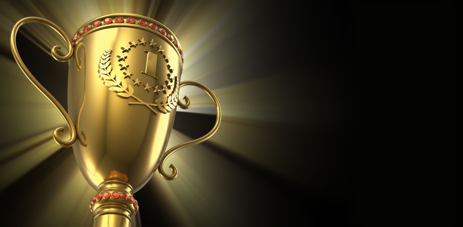 A golden tournament trophy with a 1 on it indicating first place on a dark background with golden light