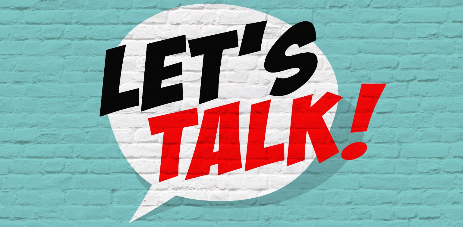 An image of the words “let’s talk” painted in black and red in a white speech bubble on a turquoise wall